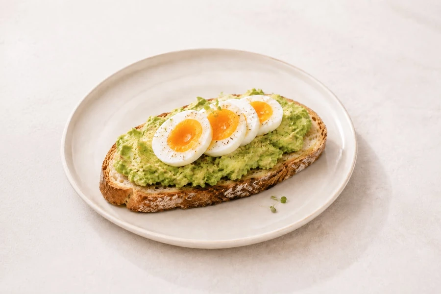 Egg and avocado smash on toasted sourdough on a ceramic plate